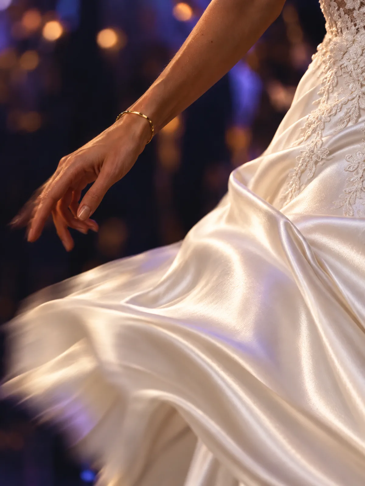 Brautkleid in der Drehung auf der Tanzfläche, im Hintergrund warme Lichter